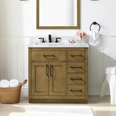 a bathroom vanity with two sinks and a mirror above it, along with a basket on the floor