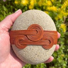 a person holding a rock with a knot on it