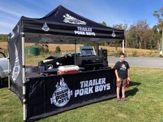 a man standing in front of a black trailer with the words trailer pork boys on it