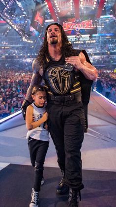 the wrestler is walking with his daughter