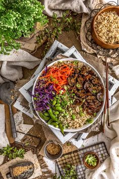 a bowl filled with rice, carrots and other vegetables on top of a table