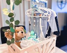 a teddy bear sitting in a basket on top of a table next to a baby's diaper