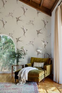 a living room filled with furniture and a wallpaper covered in hummingbirds on it