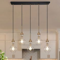 three lights hanging from the ceiling in a kitchen