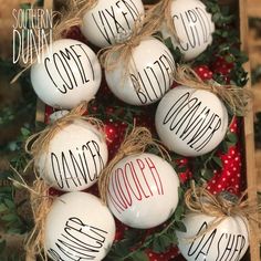 some white ornaments with words on them are sitting in a box next to strawberries