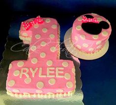 a pink cake with polka dots and a minnie mouse topper