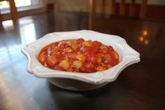 a white bowl filled with food on top of a wooden table