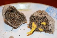 two pieces of food on a plate with dirt and yellow stuff in it's center