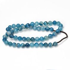 a long blue beaded necklace on a white background