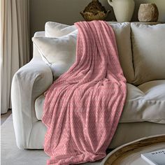 a couch with a pink blanket on top of it