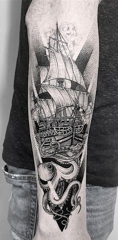 a man's arm with an octopus and ship tattoo on the back of his arm