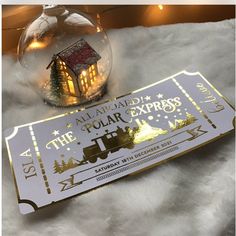 a ticket for the polar express with a christmas ornament in front of it