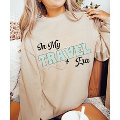 The "In My Travel Era" sweatshirt is a must-have for any travel enthusiast. With its bold lettering and simple design, it captures the adventurous spirit of exploring new destinations. Made with high-quality materials, this sweatshirt is both comfortable and durable, making it perfect for any journey. Whether you're lounging on the beach or hitting the road for a sister trip, this sweatshirt is the perfect way to show off your love of travel. It also makes a great gift for any friend or family m Long Sleeve Letter Print T-shirt For Adventure, Long Sleeve Letter Print Adventure T-shirt, Cotton Travel Tops With Letter Print, Cotton Letter Print Travel Tops, Cotton Letter Print Tops For Travel, Letter Print Crew Neck Top For Adventure, Cotton Adventure Sweatshirt With Letter Print, Travel Sweatshirt, Sister Trip