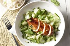 a white bowl filled with cucumber and meat