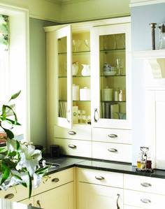 a kitchen with white cabinets and black counter tops in front of a vase filled with flowers