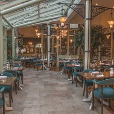 the inside of a restaurant with blue chairs and tables set up for lunch or dinner