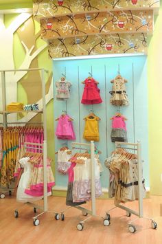 a display in a store filled with lots of baby clothes and clothing hanging on racks