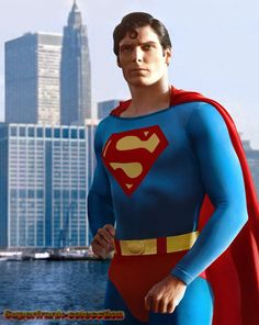 a man dressed as superman standing in front of a city