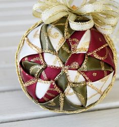 an ornament with ribbons on it sitting on a bench