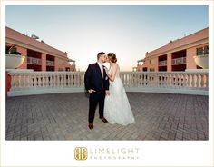 a bride and groom kissing in front of the balcony at their hotel wedding reception venue