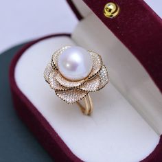 This elegant ring features a stunning 11-12mm white freshwater pearl accented by a brilliant 11-12mm Miya zirconia flower. The open closure design adds a modern touch to this timeless piece. Expertly crafted, this ring is a must-have for any pearl lover's collection. Material: 925 Sterling Silver, 4A freshwater pearl, and cubic zirconia Flexible size with open closure Large Gold Ring, Large Pearl Earrings, Mermaid Ring, Ring Pearl, Pearl Rings, Closure Design, Purple Pearl, Freshwater Pearl Bracelet, Floral Pendant