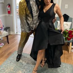 a man and woman pose for a photo in front of a statue on the floor