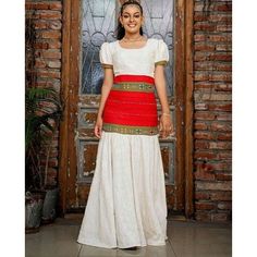 A stunning Habesha dress that is sure to leave a lasting impression. The dress features a beautiful red tilf waistband that adds a pop of color and visual interest to the dress. The rest of the dress is made from high-quality fabric that feels soft and luxurious against your skin. The white part of the dress is Almenda and the Red is Tibeb. The dress is expertly crafted to flatter your figure and accentuate your natural curves. The traditional Ethiopian neckline and sleeves add a touch of cultur Habesha Dress, Ethiopian Traditional Dress, Habesha Kemis, Traditional Fashion, Natural Curves, Traditional Dress, African Clothing, Stunning Dresses, Ethiopia