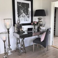 a black and white photo is hanging on the wall above a desk with two chairs