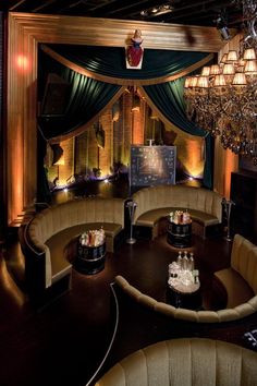 a fancy room with chandeliers and couches in front of a large screen