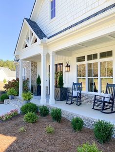 two rocking chairs on the front porch of a house