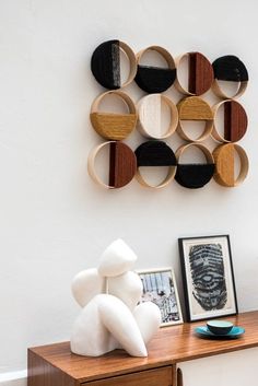 a wooden table topped with a white stuffed animal next to a wall mounted art piece