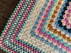 a crocheted blanket with multicolored circles on it