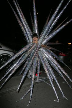 a man is dressed up as a giant starburst in the street at night