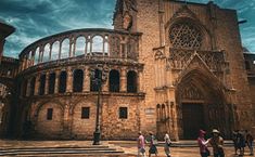 people are walking around in front of an old building