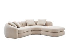 the curved sectional sofa has four pillows on it's back and is made out of fabric