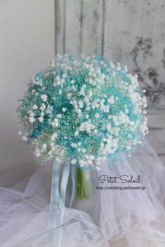 a bridal bouquet with baby's breath in it sitting on a white table