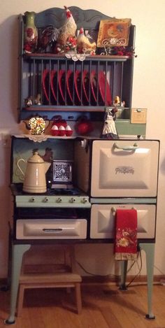 an old fashioned stove and oven are on display in a room with wood floors, white walls and wooden flooring