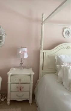 a bedroom with pink walls and white furniture