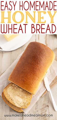 a loaf of homemade honey wheat bread sitting on top of a piece of parchment paper