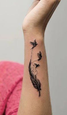 a woman's wrist with a feather tattoo on it