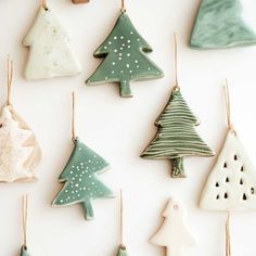 christmas ornaments are hanging on the wall in various shapes and sizes, including trees with snowflakes