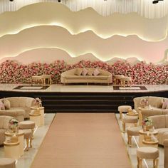 a stage set up for a wedding with couches and chairs in front of it