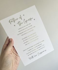 a person holding up a piece of paper with the words father of the groom written on it