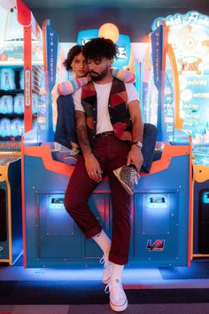 a man sitting on top of a woman in front of a vending kiosk