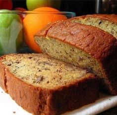 sliced loaf of banana bread next to apples and oranges