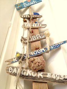 a wooden pole with various signs hanging from it's sides and ropes attached to it