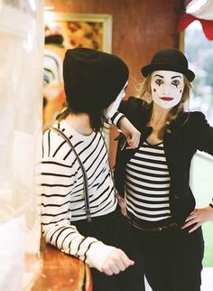 two women dressed up as clowns and one is wearing a striped shirt with black pants