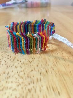 a colorful bracelet sitting on top of a wooden table