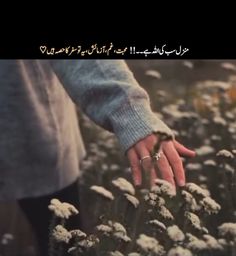 someone holding the hand of another person in a field of flowers with arabic writing on it