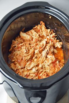 an open crock pot filled with shredded meat